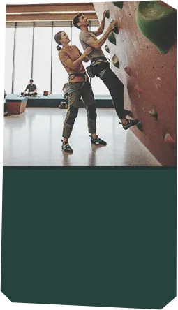 Monitor ayudando a una escaladora en su primer curso